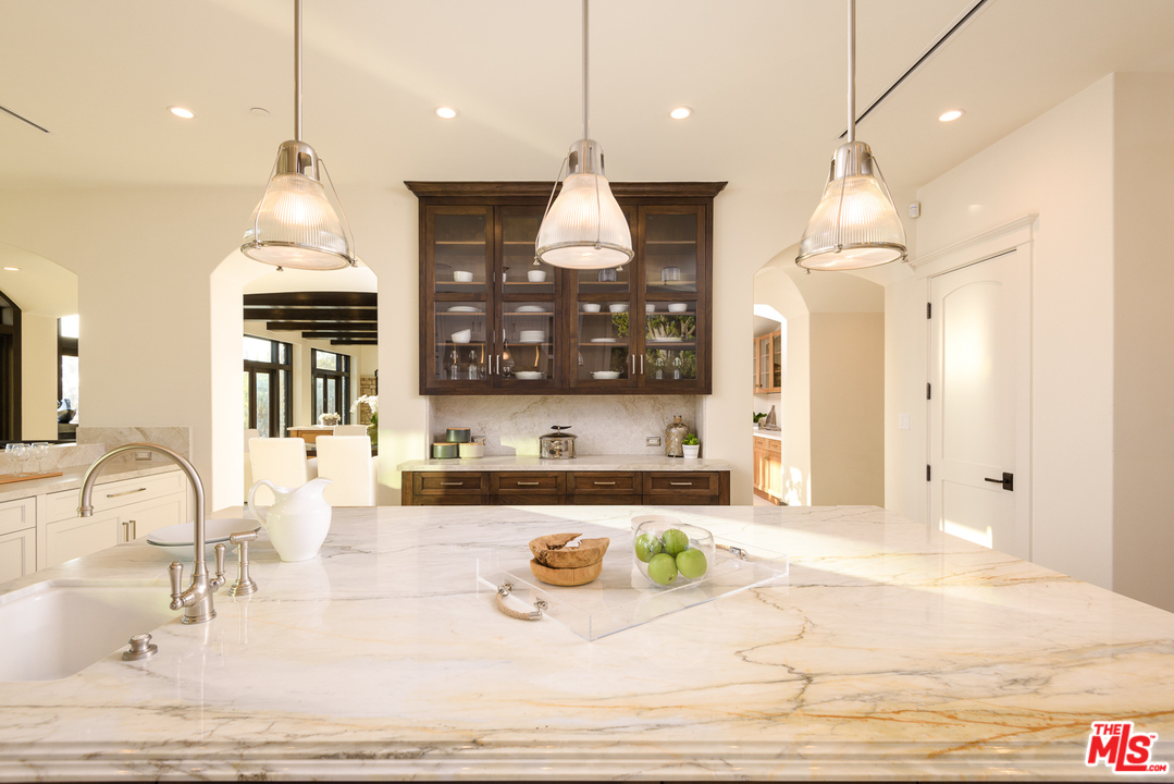 2175 Summitridge Drive Beverly Hills, CA 90210 - Photo 21 of 51 a room with granite countertop wooden floor and chandelier