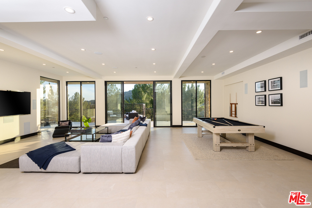 2175 Summitridge Drive Beverly Hills, CA 90210 - Photo 37 of 51 a living room with furniture flat screen tv and a large window