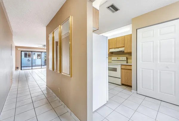 a view of a kitchen from the hallway with a window