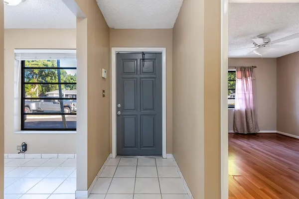 a view of a hallway with wooden floor and a living room