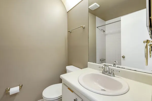 a bathroom with a sink toilet and a mirror