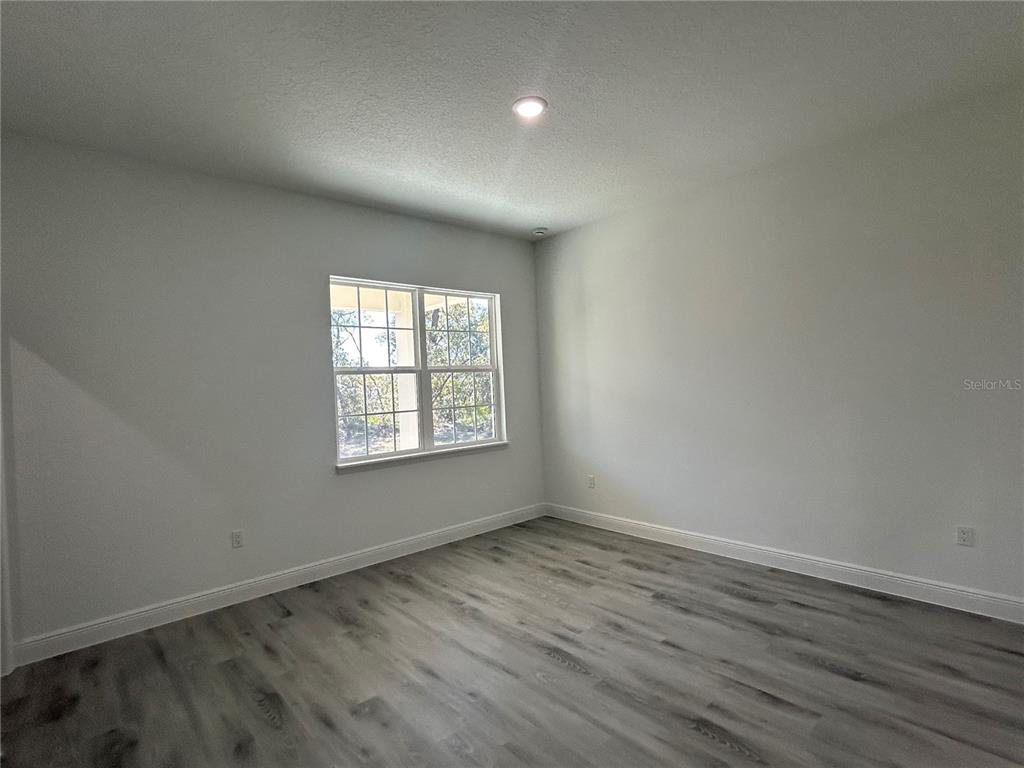 555 Marion Oaks Golf Road Ocala, FL 34473 - Photo 15 of 34 an empty room with wooden floor and windows