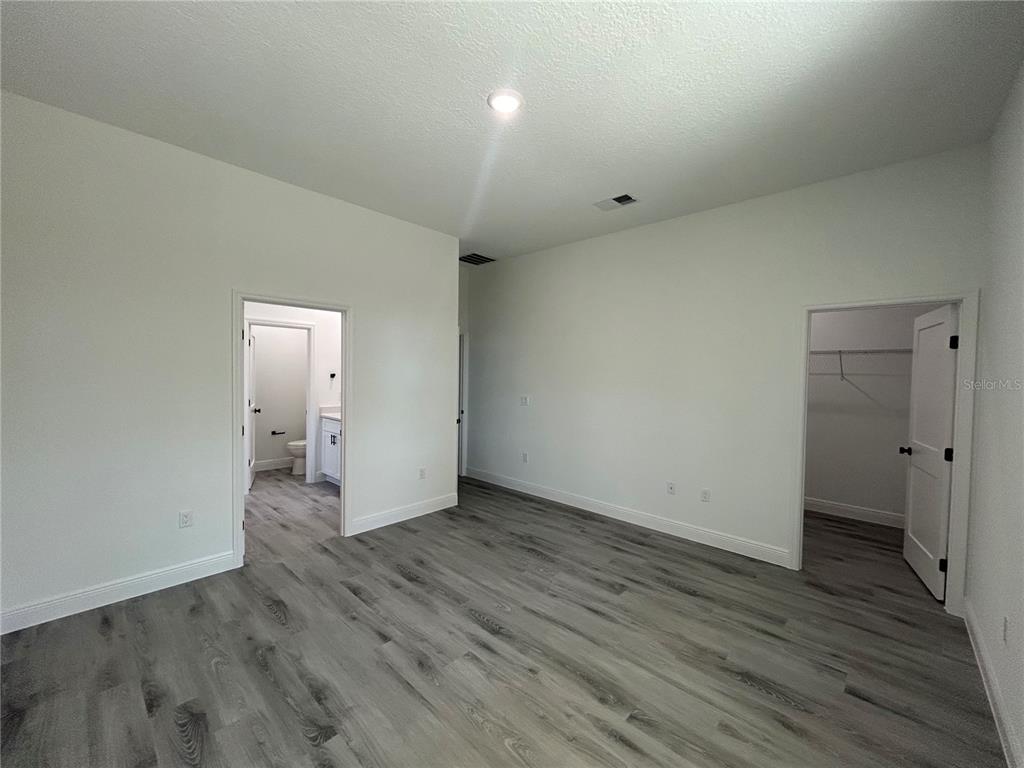 555 Marion Oaks Golf Road Ocala, FL 34473 - Photo 16 of 34 a view of an empty room with wooden floor and a bathroom