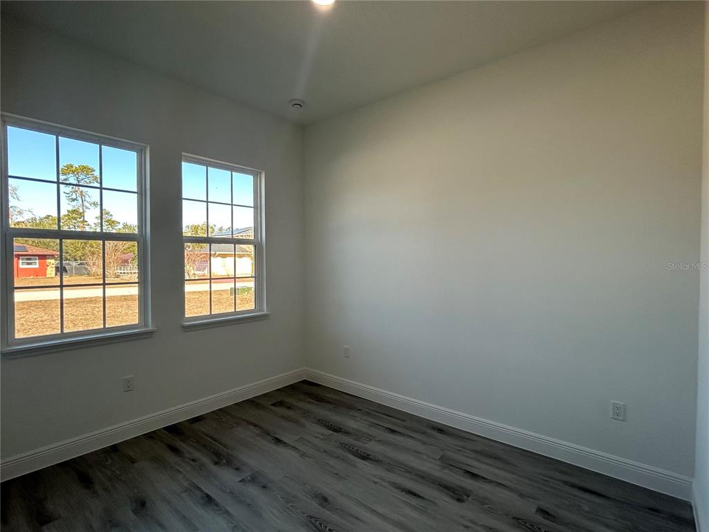 555 Marion Oaks Golf Road Ocala, FL 34473 - Photo 24 of 34 an empty room with wooden floor and windows
