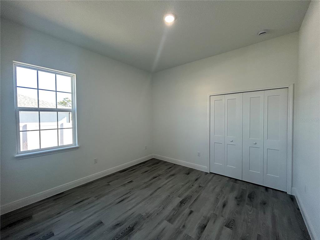 555 Marion Oaks Golf Road Ocala, FL 34473 - Photo 27 of 34 an empty room with wooden floor and windows