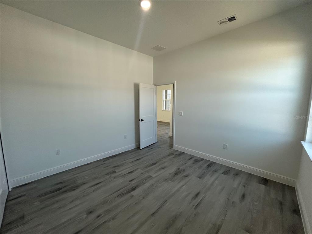 555 Marion Oaks Golf Road Ocala, FL 34473 - Photo 28 of 34 a view of an empty room with wooden floor
