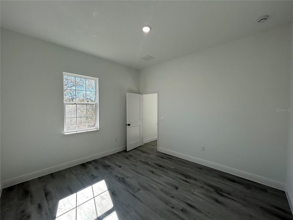 555 Marion Oaks Golf Road Ocala, FL 34473 - Photo 30 of 34 an empty room with wooden floor and windows
