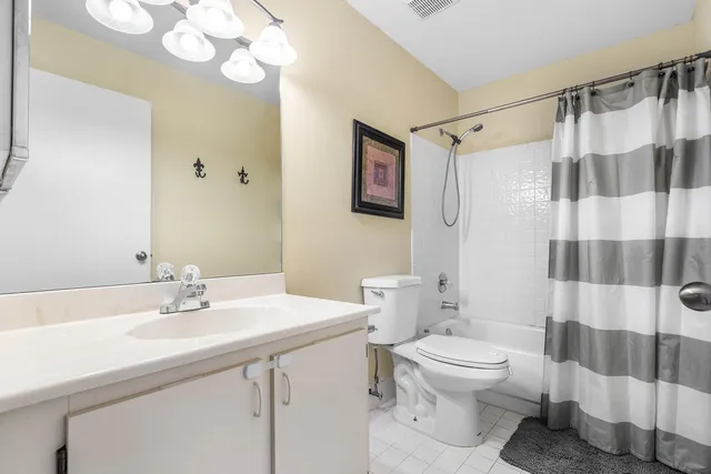 a bathroom with a sink a toilet a mirror a vanity and shower