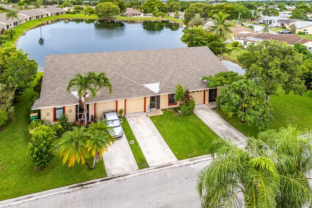 an aerial view of a house with a yard and lake view