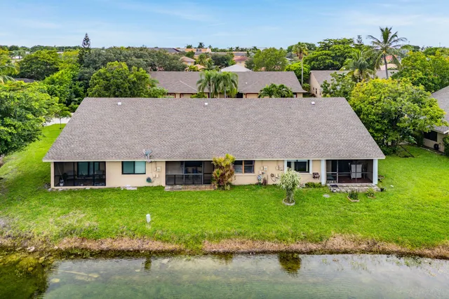 an aerial view of a house with a yard and lake view