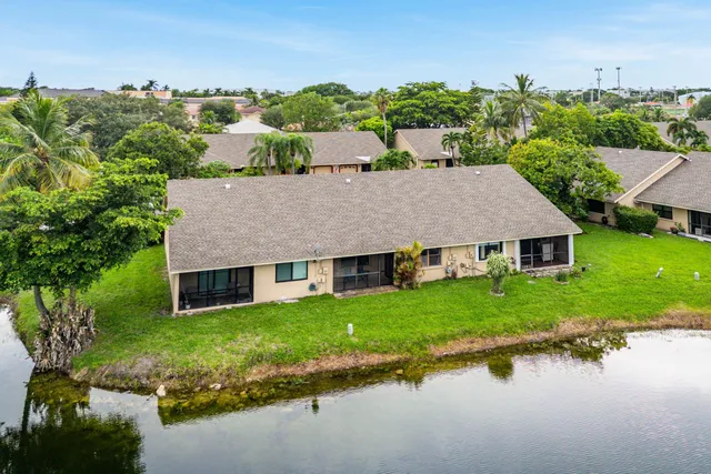 a aerial view of a house with a yard and lake view