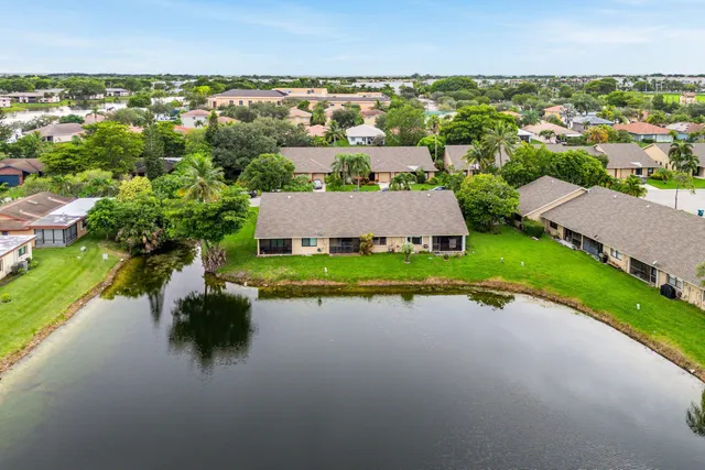 an aerial view of a house with a garden and lake view