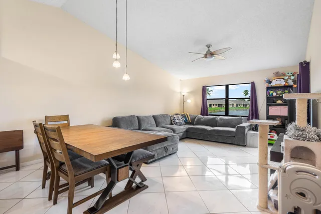 a living room with furniture and a dining table with bookshelf