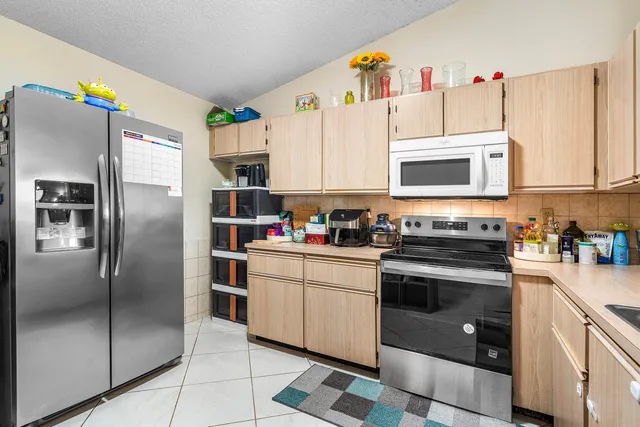 a kitchen with stainless steel appliances granite countertop a refrigerator sink and microwave