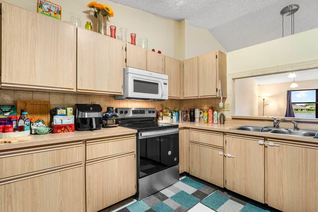 a kitchen with white cabinets sink and white appliances