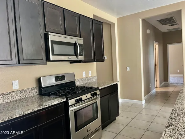 a kitchen with granite countertop a stove and a microwave