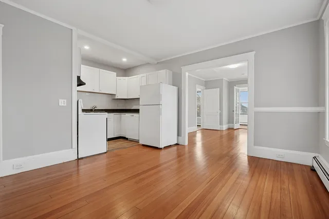 a view of kitchen with wooden floor and electronic appliances