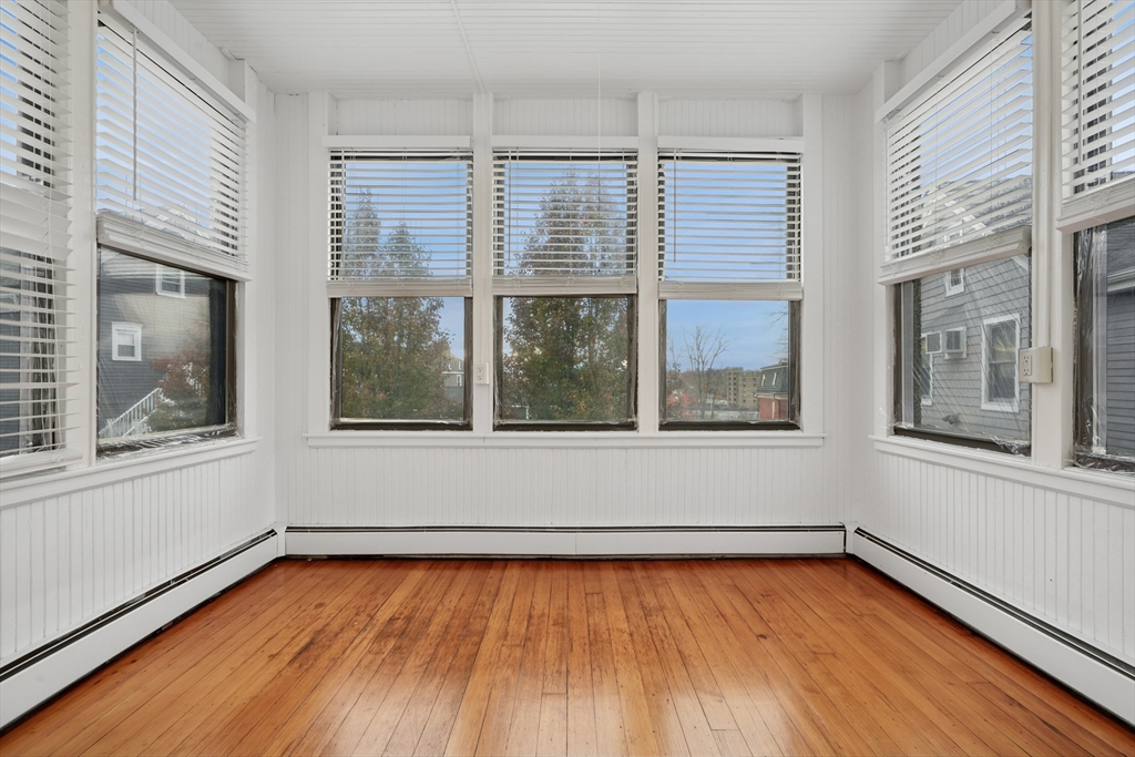 55 Summer Street, Unit 1 Haverhill, MA 01830 - Photo 5 of 13 a view of an empty room with wooden floor and a window