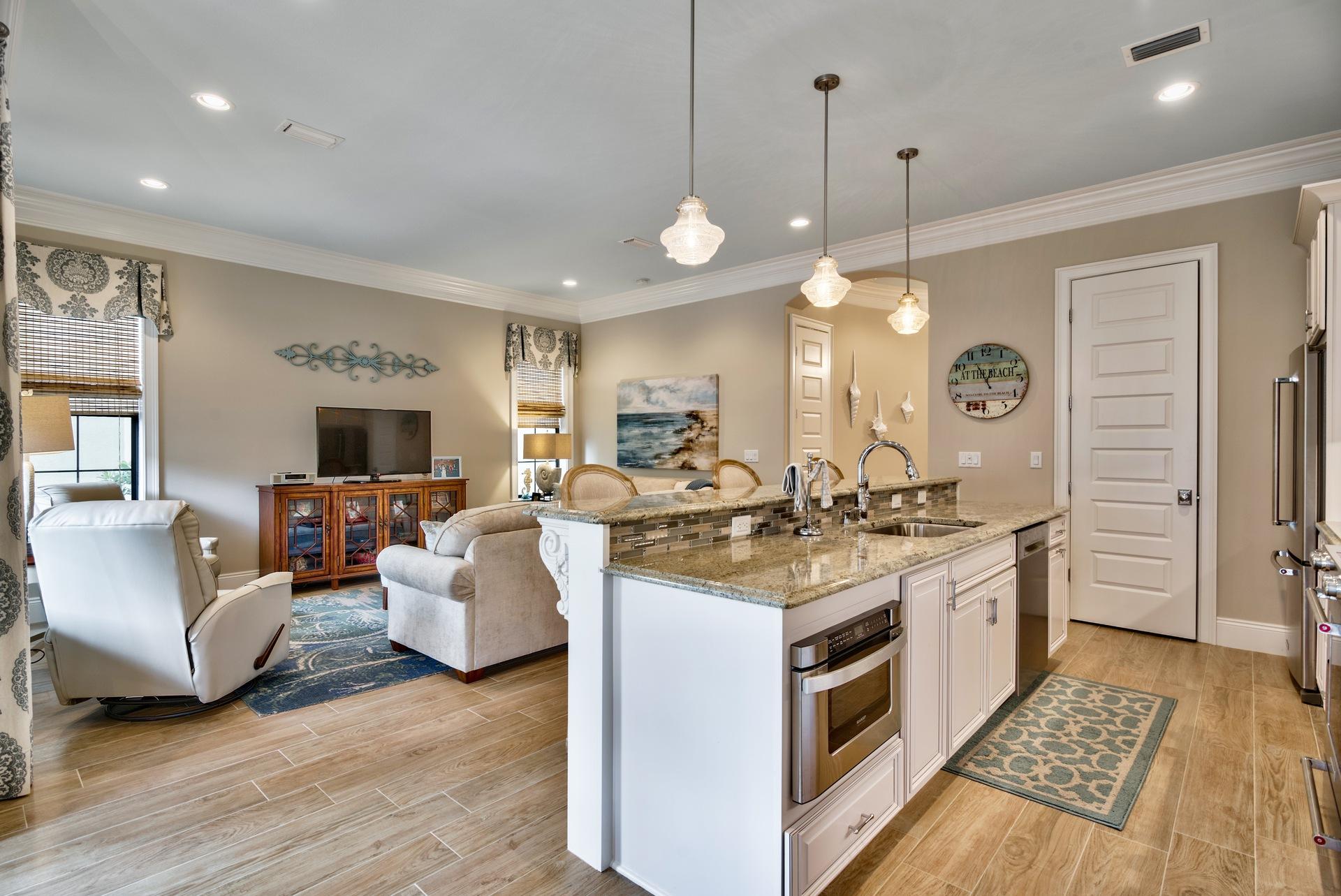 1976 Baytowne Loop Miramar Beach, FL 32550 - Photo 23 of 23 a large kitchen with kitchen island a stove a sink a chimney wooden floor and a dining table