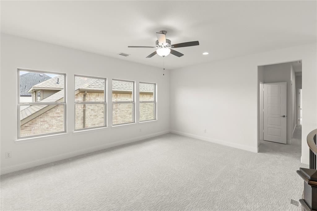 1724 Ruby Way Rockwall, TX 75087 - Photo 19 of 29 an empty room with chandelier fan and windows