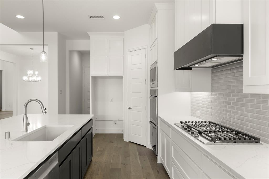 1724 Ruby Way Rockwall, TX 75087 - Photo 10 of 29 a kitchen with stainless steel appliances granite countertop a sink stove and refrigerator
