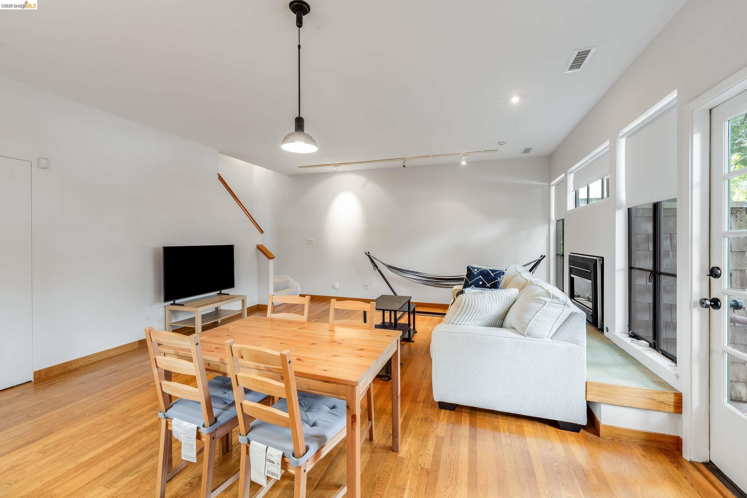 2316 Blake Street, Unit A Berkeley, CA 94704 - Photo 12 of 30 Living room featuring rail lighting, a glass covered fireplace, and light wood-type flooring