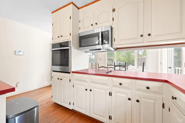 a view of a kitchen with refrigerator and a window