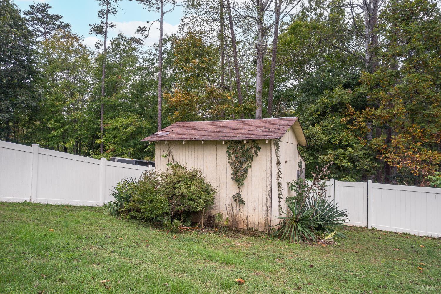 111 East Otter Ridge Drive Goode, VA 24556 - Photo 54 of 62 a view of a wooden house with a small yard and large trees