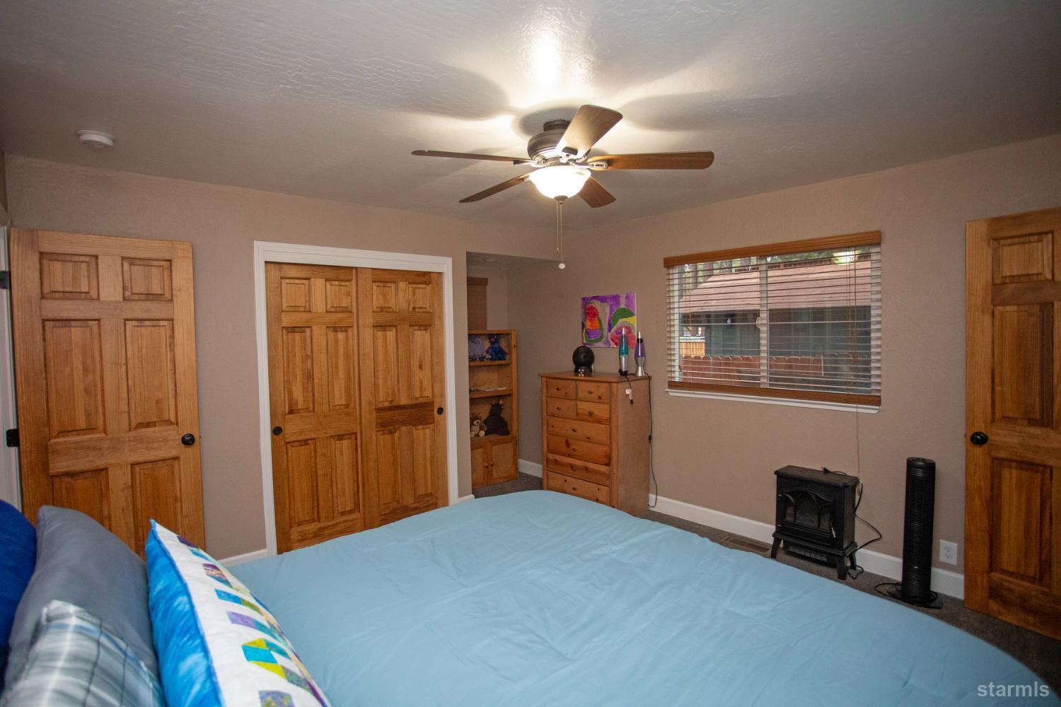 2569 Alma Avenue South Lake Tahoe, CA 96150 - Photo 15 of 35 a bedroom with a bed and a chandelier