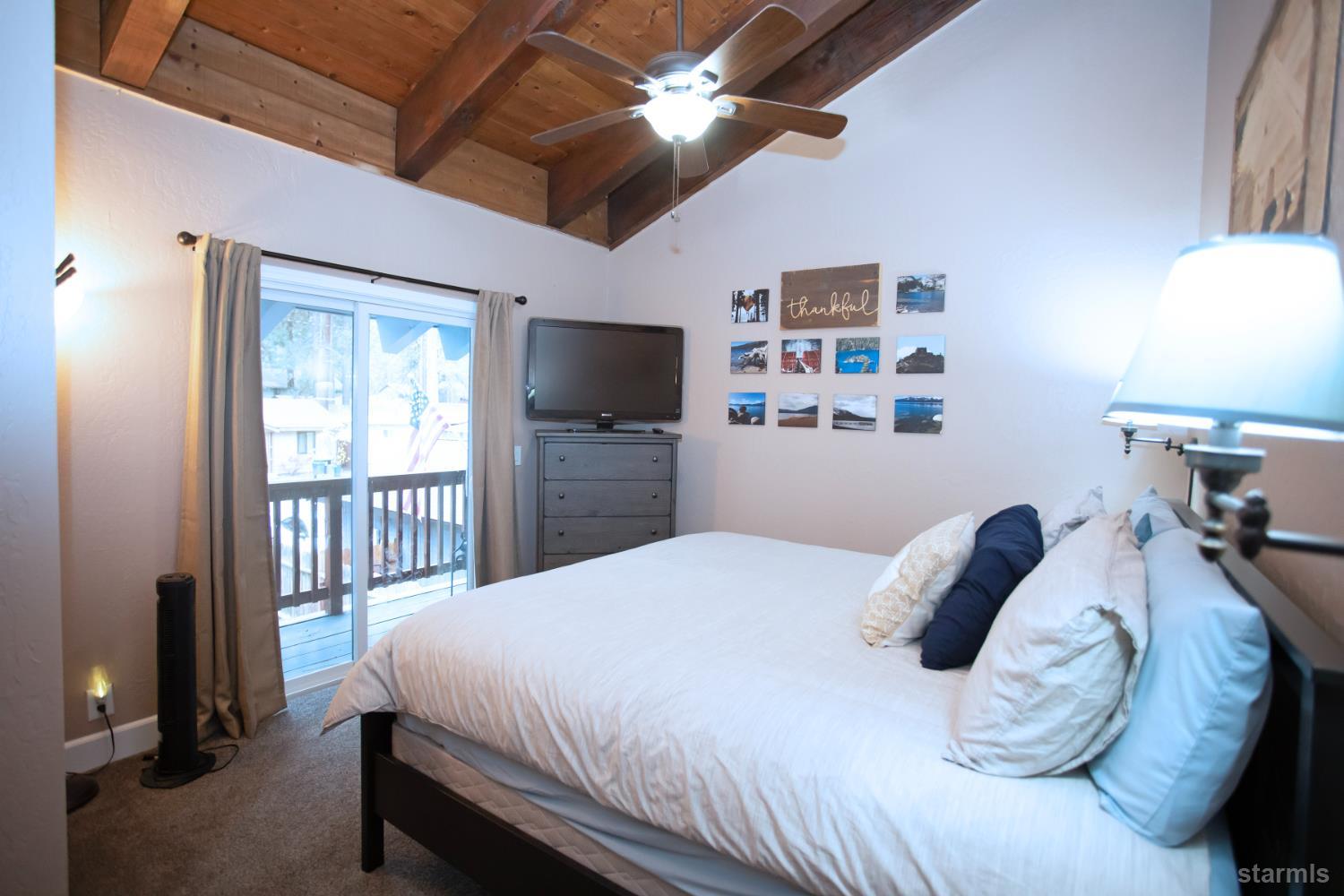 2569 Alma Avenue South Lake Tahoe, CA 96150 - Photo 29 of 35 a bedroom with a bed and a flat tv screen on dresser