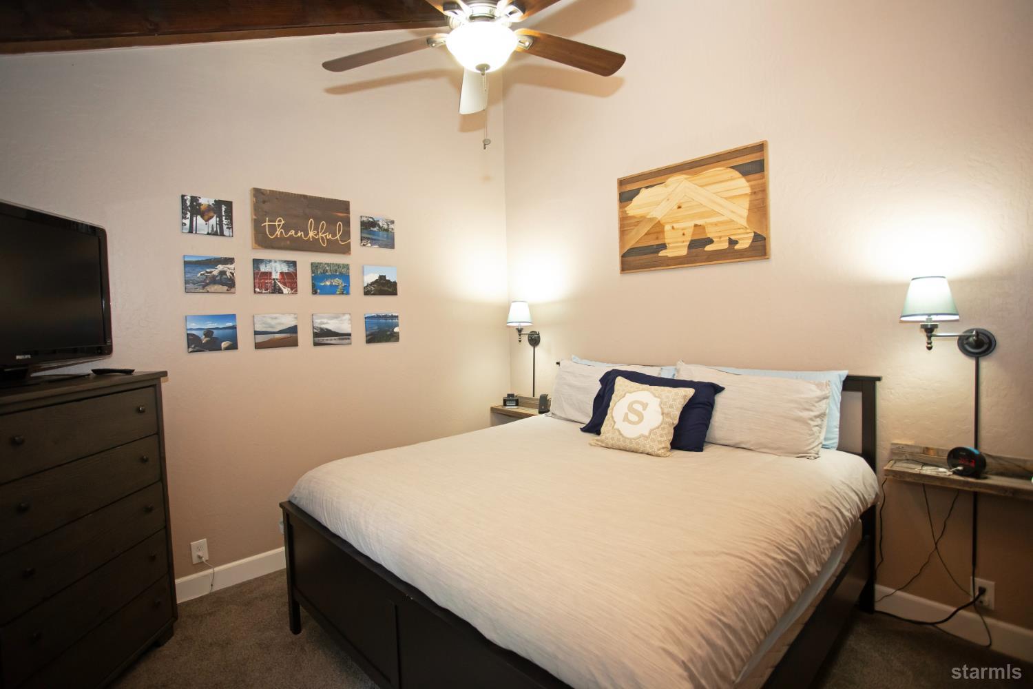 2569 Alma Avenue South Lake Tahoe, CA 96150 - Photo 31 of 35 a bedroom with a bed and a flat tv screen on the dresser