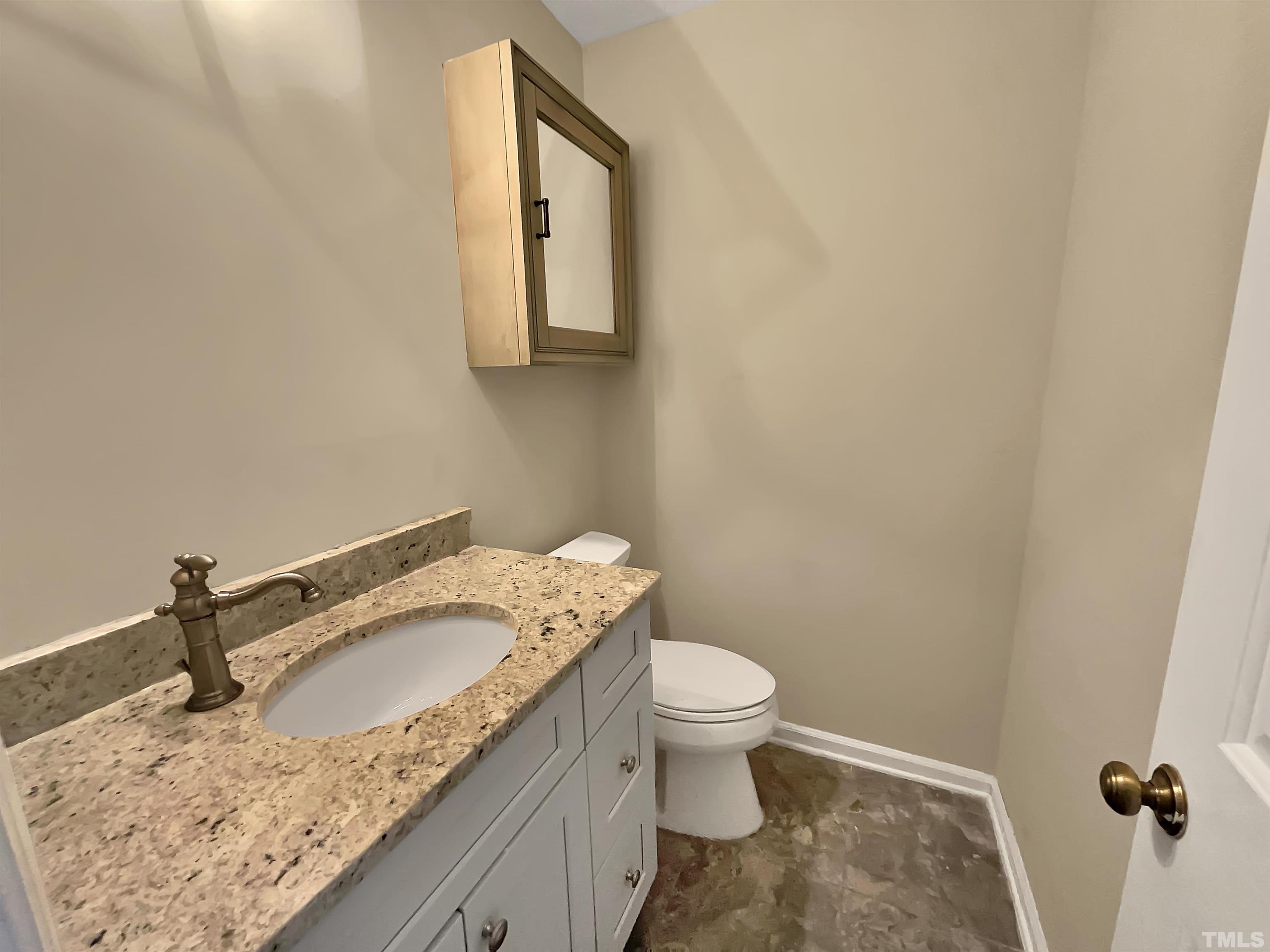 4101 Kaplan Drive Raleigh, NC 27606 - Photo 13 of 22 a bathroom with a granite countertop sink a toilet and mirror