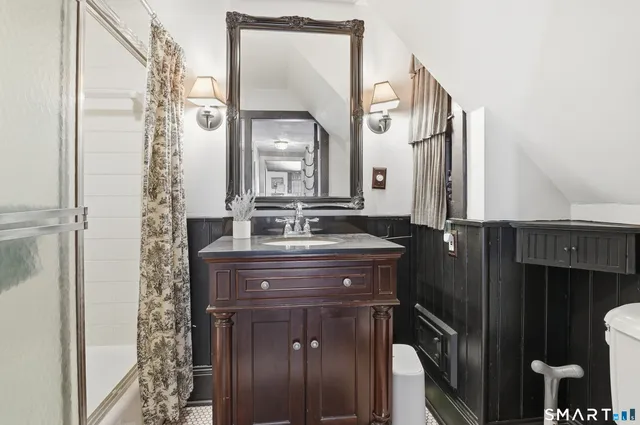 a bathroom with a granite countertop sink a mirror and a shower
