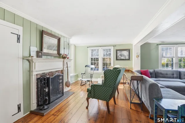 a living room with furniture fireplace and wooden floor