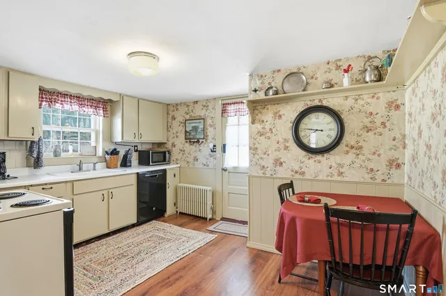 a kitchen with a cabinets a stove top oven a clock and a window