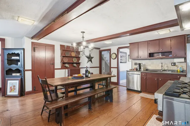 a kitchen with granite countertop a table chairs stove and refrigerator