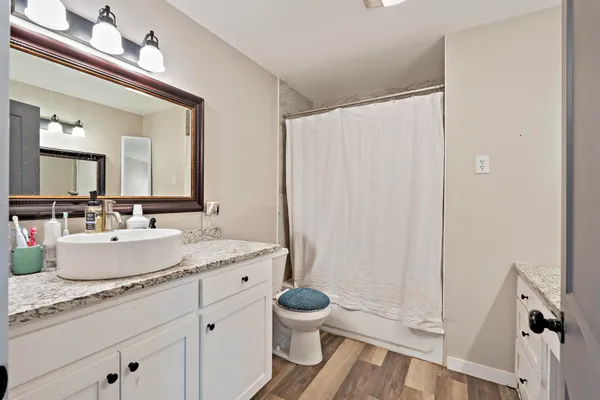 a en suite bathroom with a granite countertop sink and a mirror