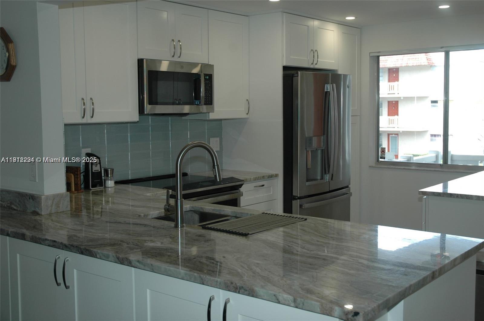 3571 Inverrary Drive, Unit 201 Lauderhill, FL 33319 - Photo 2 of 48 a kitchen with stainless steel appliances granite countertop a sink a microwave and wooden cabinets