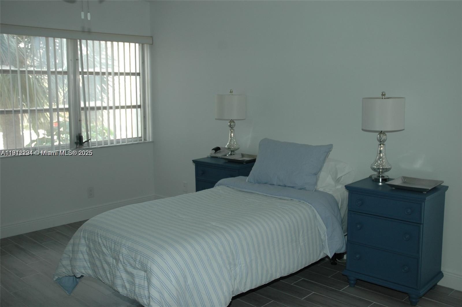 3571 Inverrary Drive, Unit 201 Lauderhill, FL 33319 - Photo 41 of 48 a bedroom with a bed and a night stand