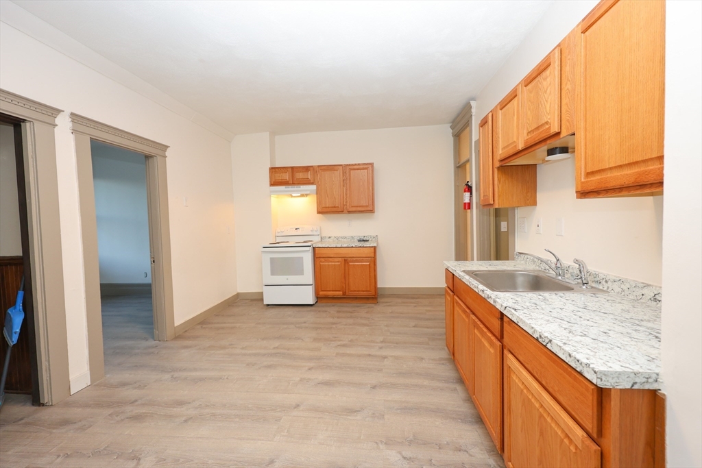 a kitchen with stainless steel appliances granite countertop a sink and a refrigerator