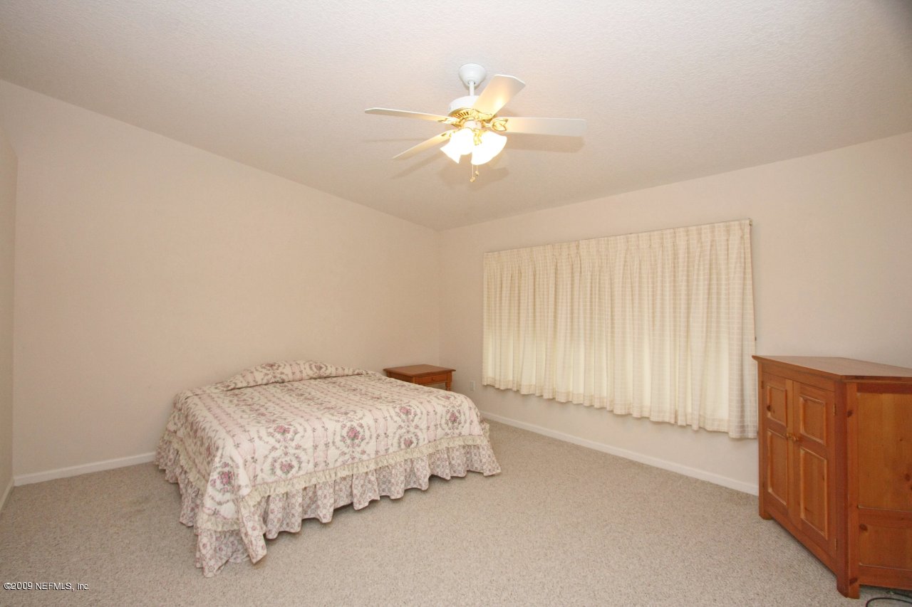 3109 Ravines Road Middleburg, FL 32068 - Photo 8 of 14 a bedroom with a bed and a chandelier