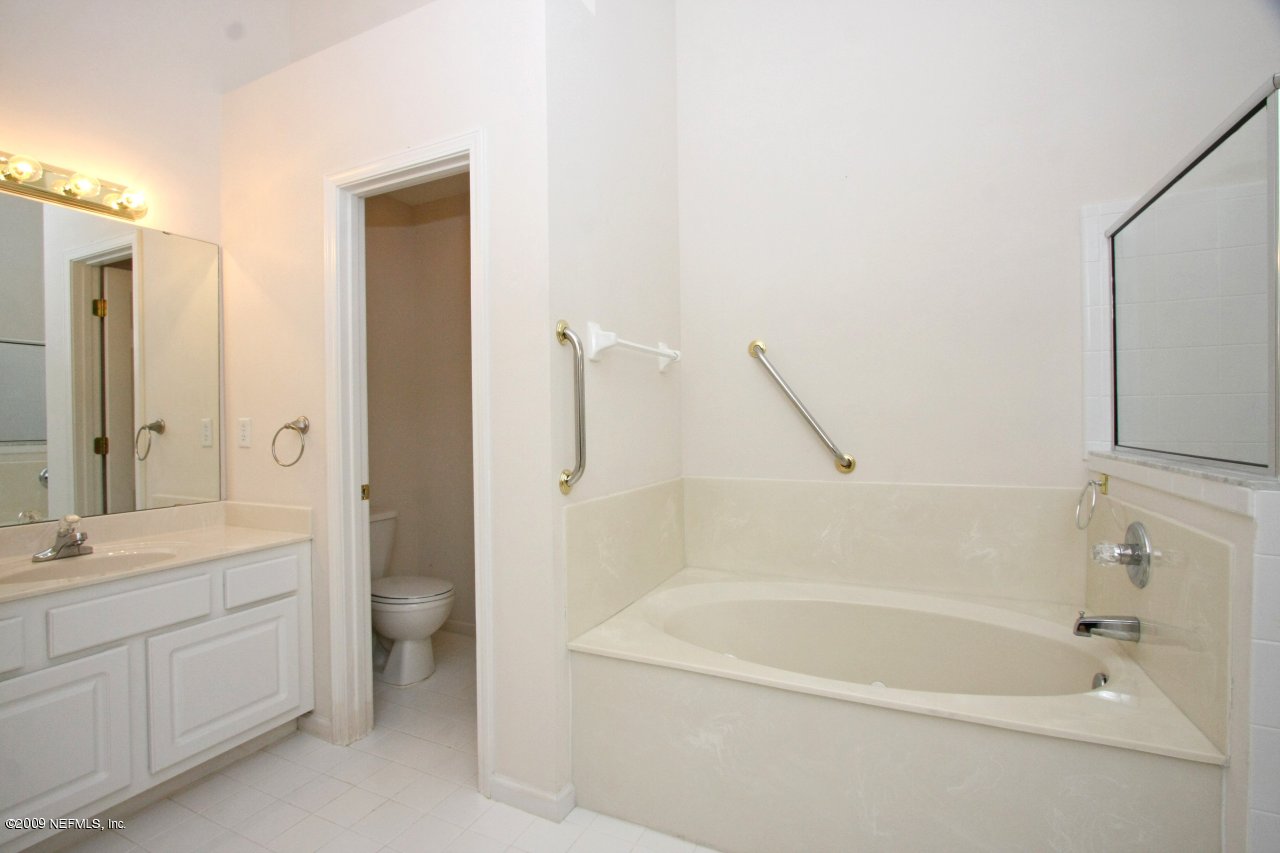 3109 Ravines Road Middleburg, FL 32068 - Photo 9 of 14 a spacious bathroom with a granite countertop sink a toilet and a bathtub