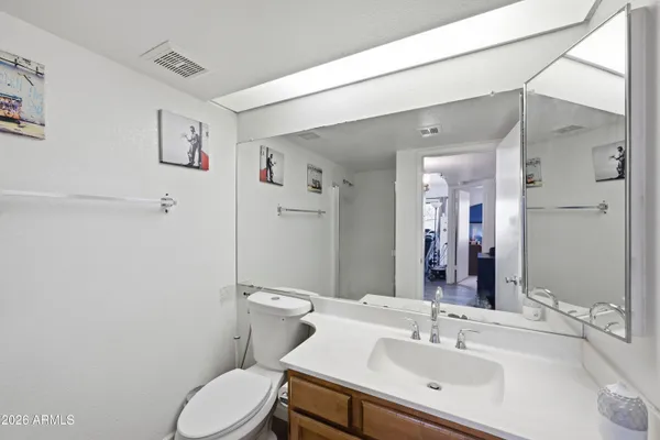 a bathroom with a sink mirror vanity and toilet