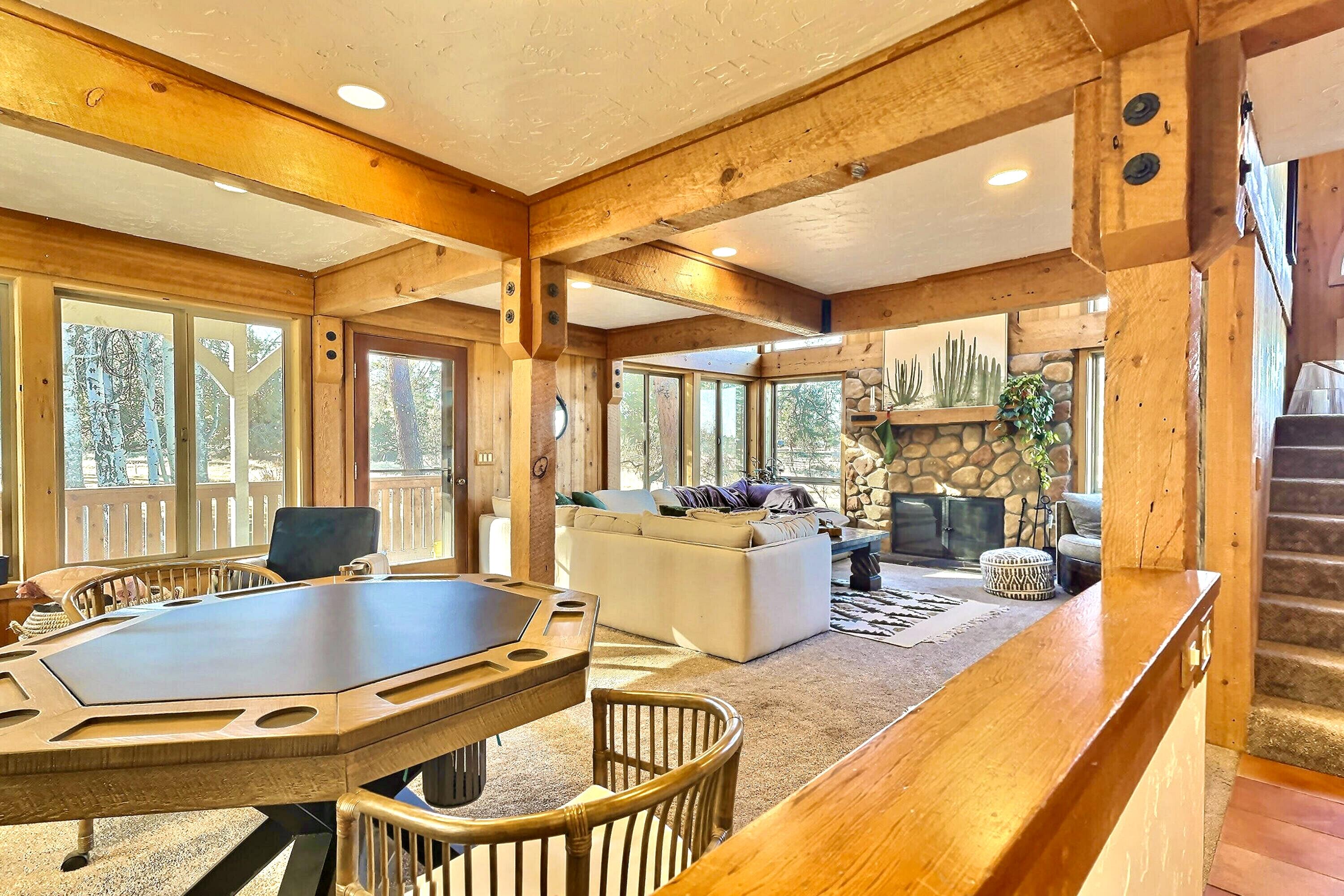 60359 Arnold Market Road Bend, OR 97702 - Photo 8 of 64 main living area with game table, reading nooks and vaulted ceiling tv lounge with huge wood-burning fireplace. Windows galore