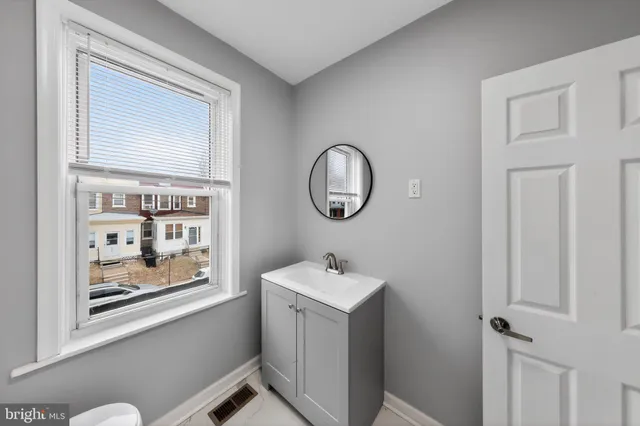 a bathroom with a sink a mirror and a window