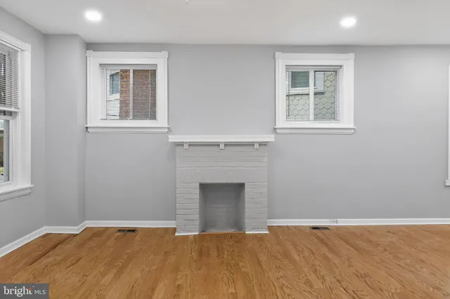 a view of an empty room with a window and fireplace