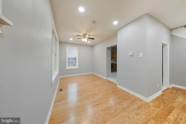 a view of a big room with windows and chandelier fan
