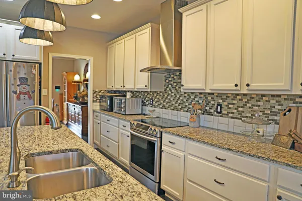 a kitchen with stainless steel appliances granite countertop a sink and a stove