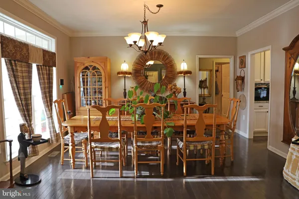 a room with lots of white furniture and wooden floor