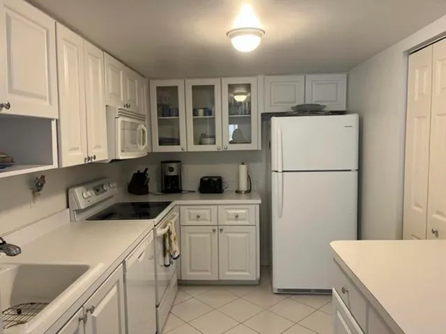 a kitchen with a refrigerator a stove a sink and cabinets